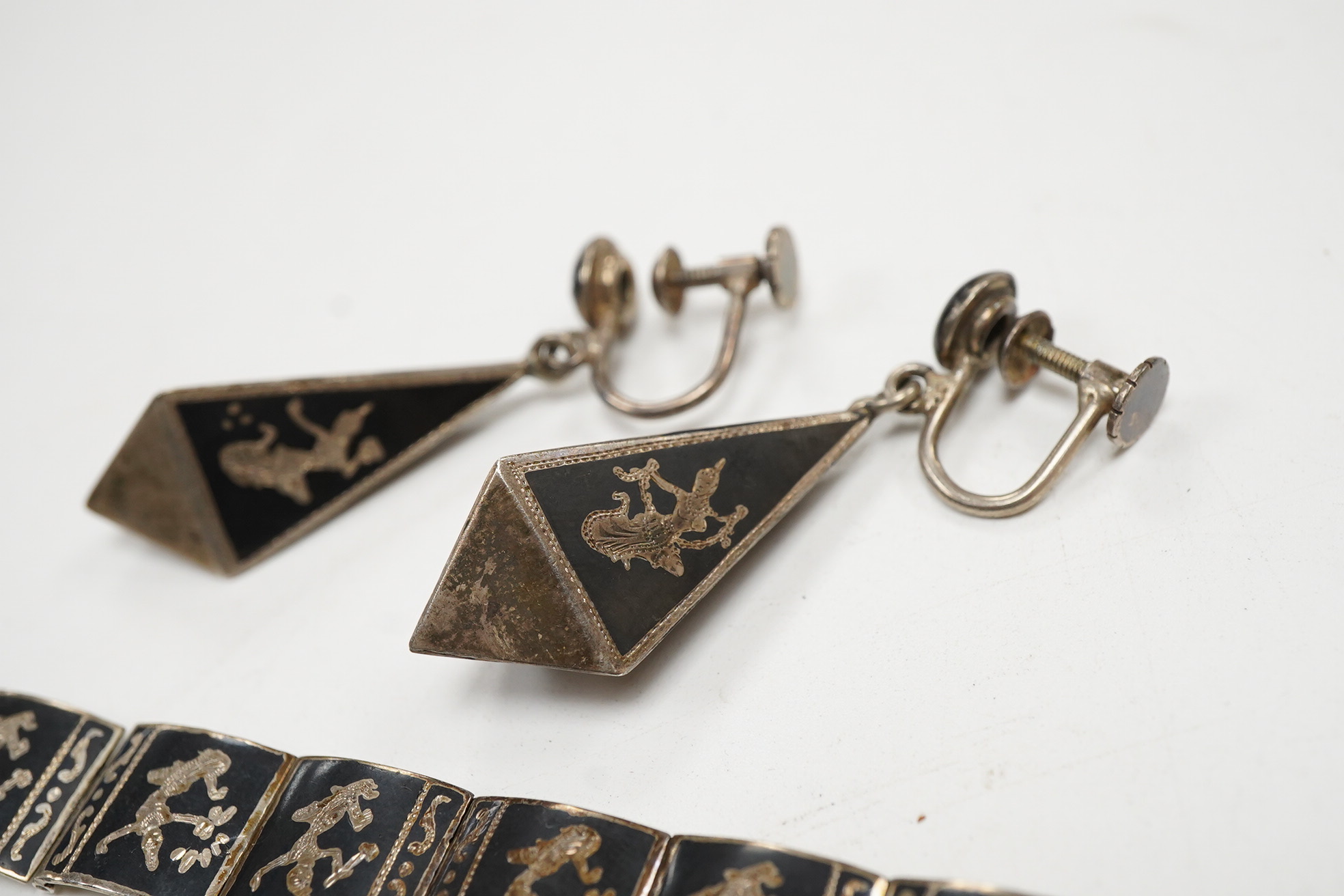 A Thai sterling and niello bracelet, 16.2cm, together with a pair of similar earrings.